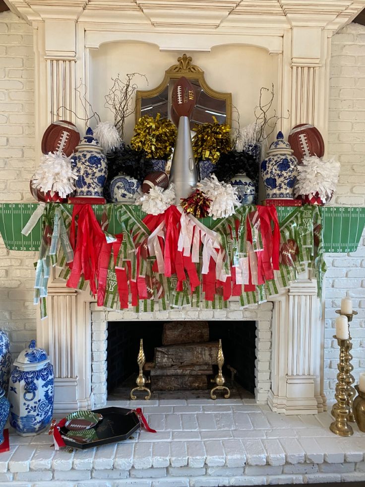 a mantel decorated with footballs, pom poms and streamers in front of a fireplace