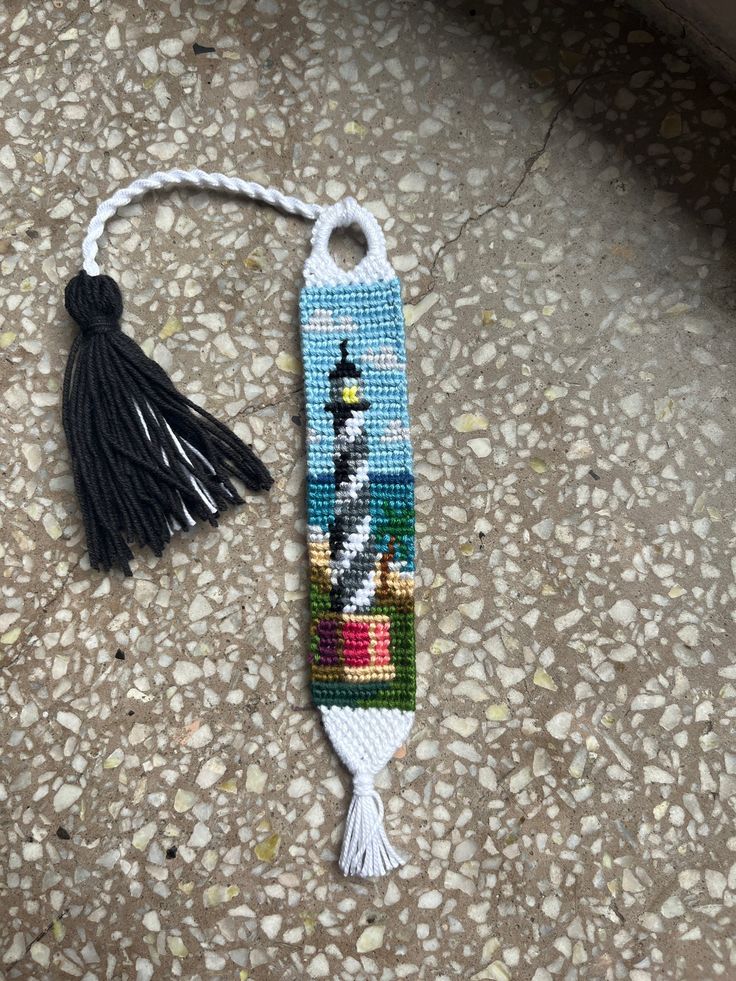 a small beaded bookmark with a tassel hanging from it's side