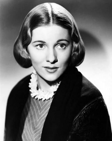 an old black and white photo of a woman with short hair wearing a collared sweater