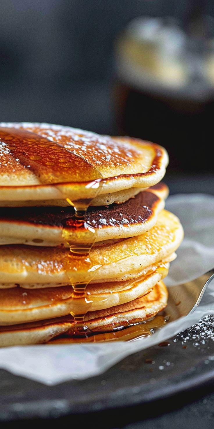 a stack of pancakes on a plate with syrup