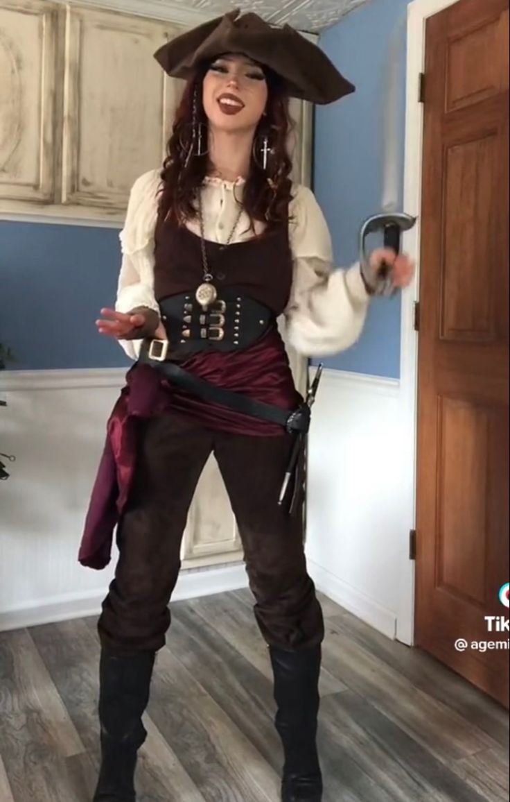 a woman dressed in pirate costume standing on the floor with her hands out and smiling