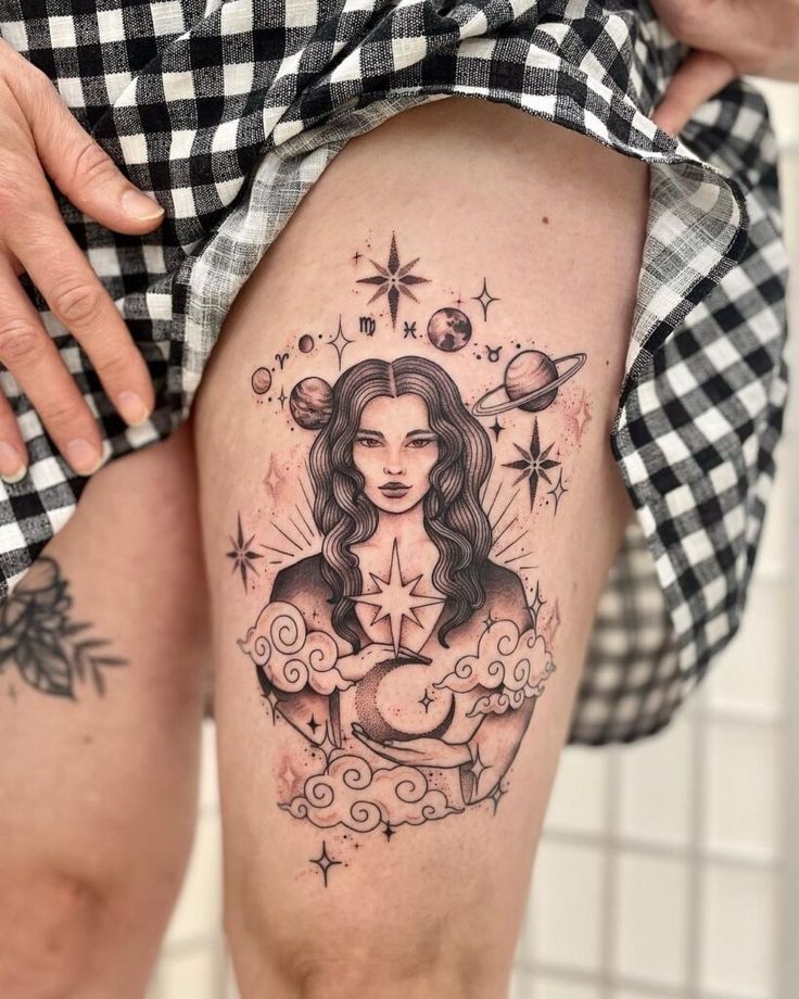 a woman's thigh with tattoos on it and an image of the virgin mary