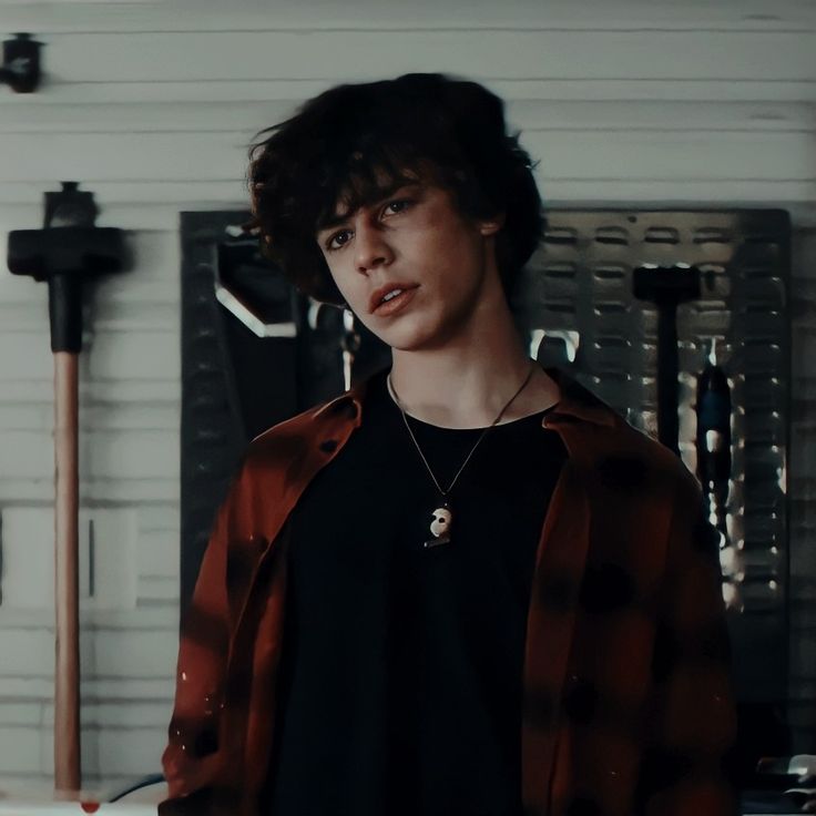 a young man standing in front of some tools