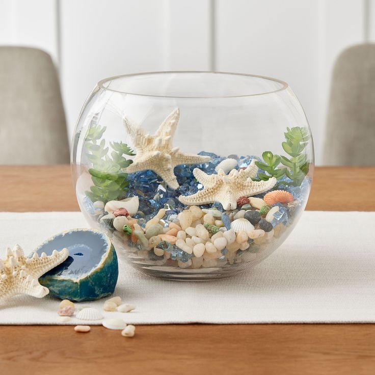 a glass bowl filled with sea shells and starfish