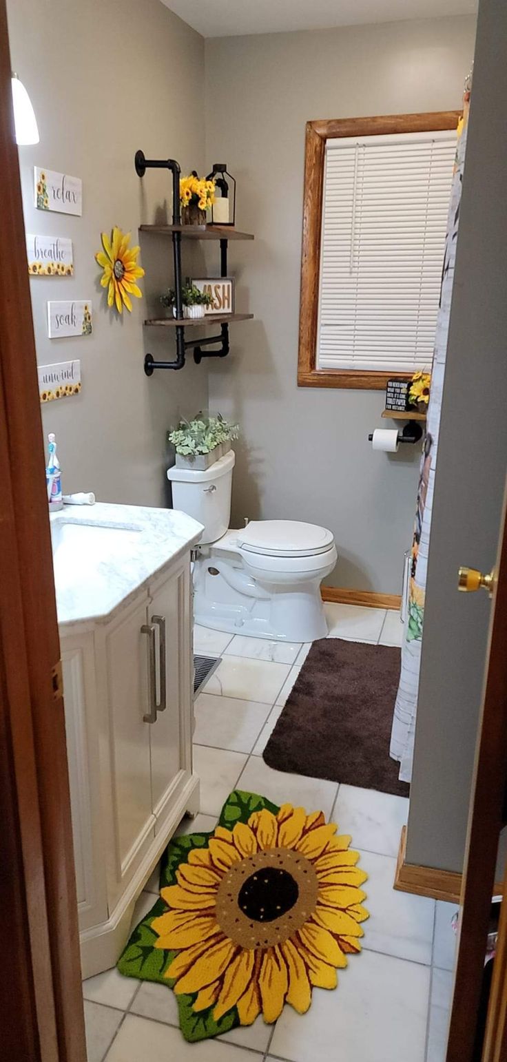 a bathroom with a sunflower rug on the floor