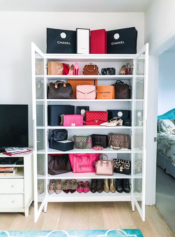 a white shelf filled with lots of purses