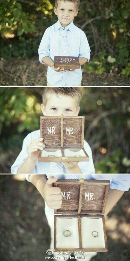 a little boy that is holding up some kind of wooden block with the words mr and mrs on it