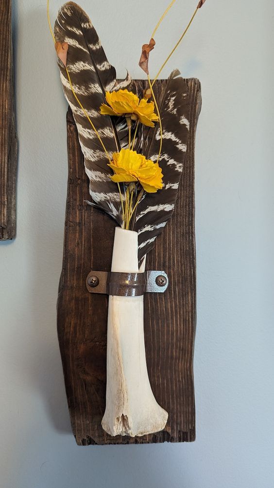 a vase filled with yellow flowers sitting on top of a wooden wall