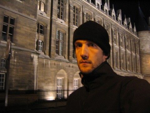 a man standing in front of a large building