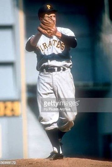 a baseball player standing on top of a field holding his hand up to his face