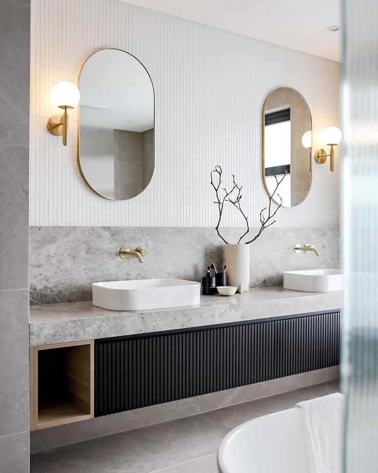 a bathroom with two sinks and mirrors on the wall