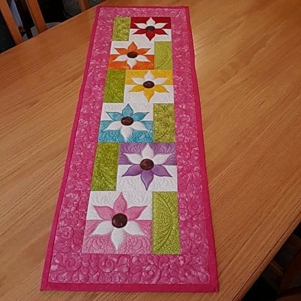 the table runner is made from pink and green material