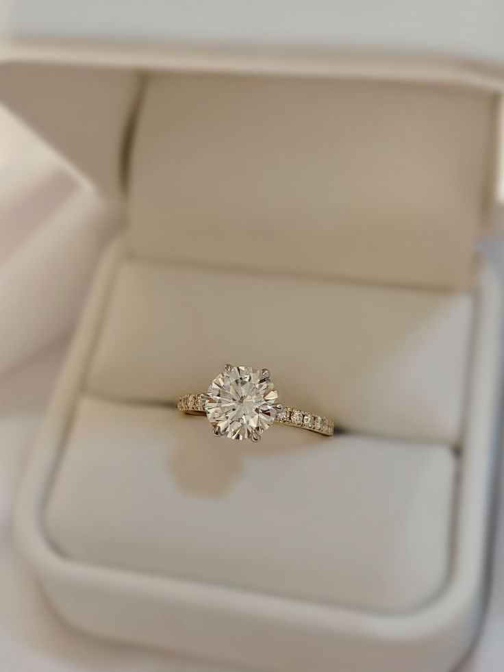 an engagement ring in a white box