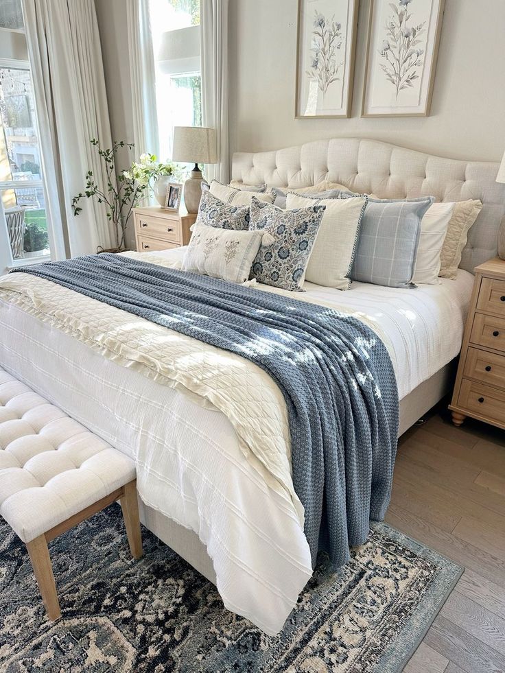 a large bed sitting in a bedroom next to a window