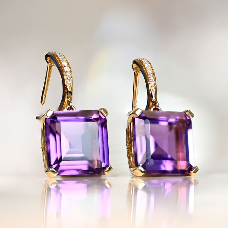 This pair of gemstone earrings features emerald-cut amethysts with a combined weight of 8.18 carats, set in baskets of 18k yellow gold. The closures are latch-backs, and are set along the front with single cut diamonds. The total diamond weight of both earrings is approximately 0.13 carats.
The length of these earrings is approximately 2.3cm.
If you have any questions about the Sayville earrings, please feel free to contact us. Vintage Diamond Earrings, Dream Dark, Asscher Cut Ring, Fancy Diamond Ring, Estate Diamond Jewelry, Shiny Rings, Designer Diamond Jewellery, Colored Diamond Rings, Jewelry Education