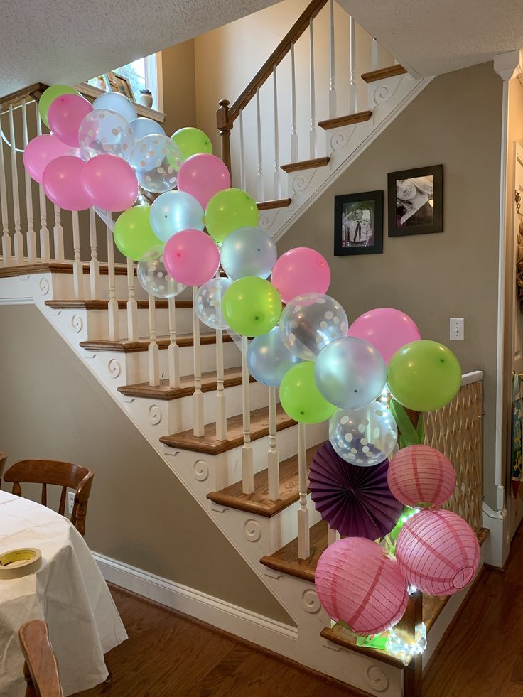 a staircase decorated with balloons and streamers for a baby shower or birthday party at home