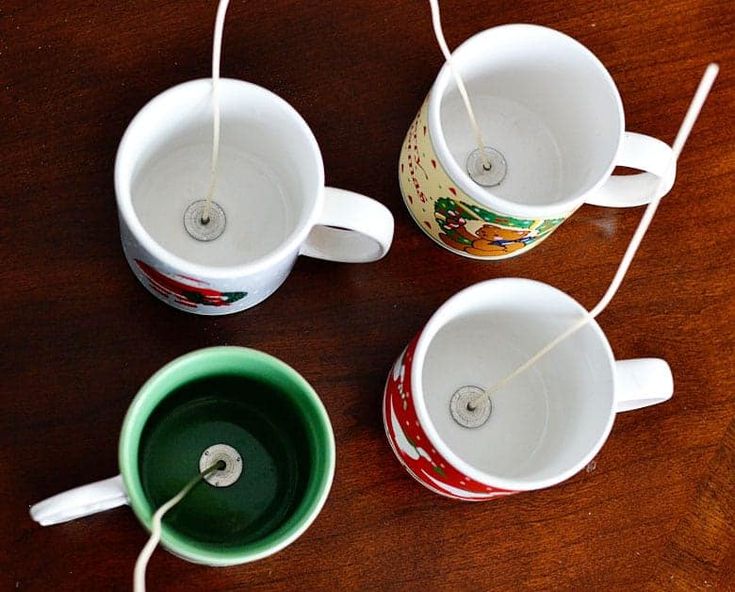 three coffee mugs sitting on top of a wooden table with string attached to them