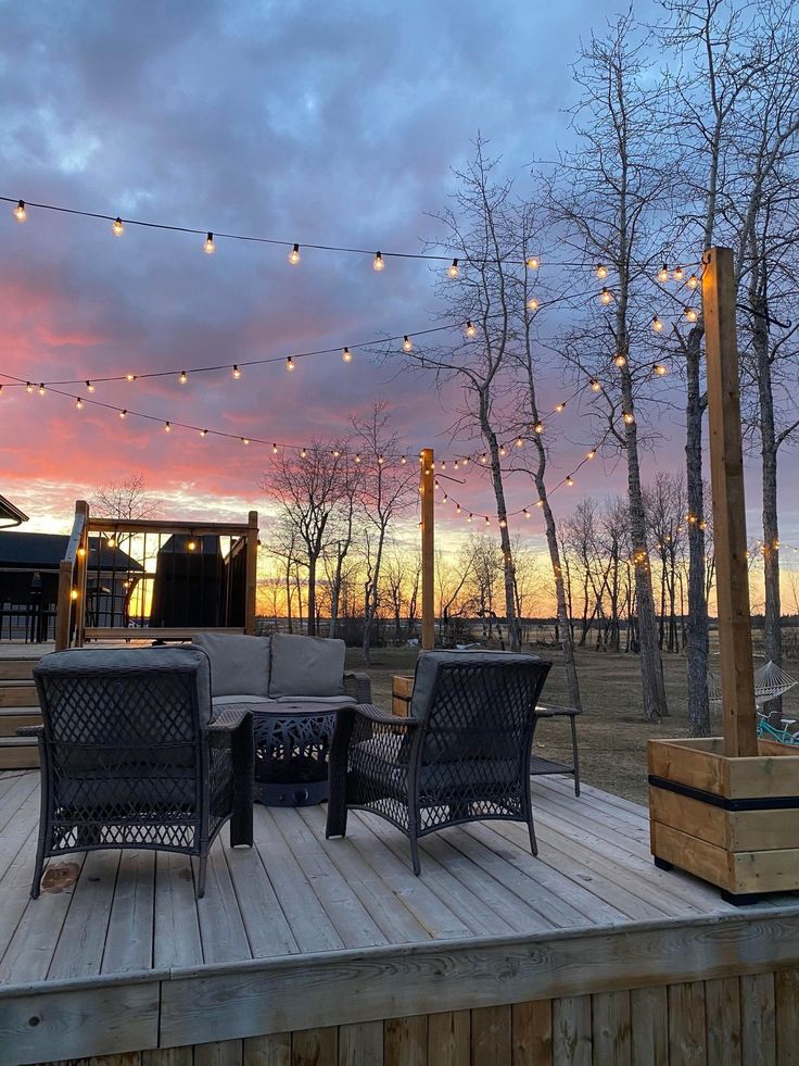 a deck with patio furniture and string lights