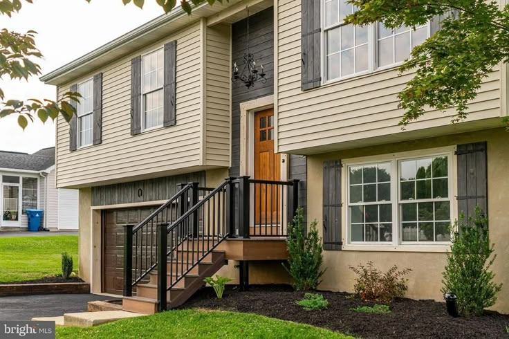 two story house with stairs leading to the front door