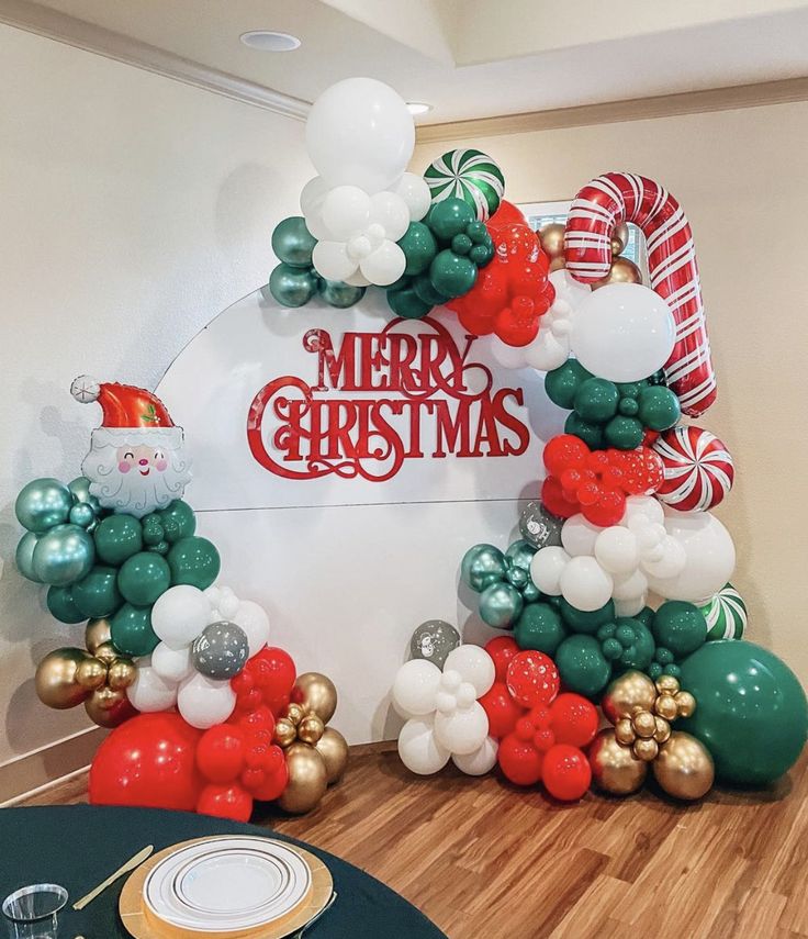 a christmas balloon arch with santa clause and candy canes on the top, along with other balloons