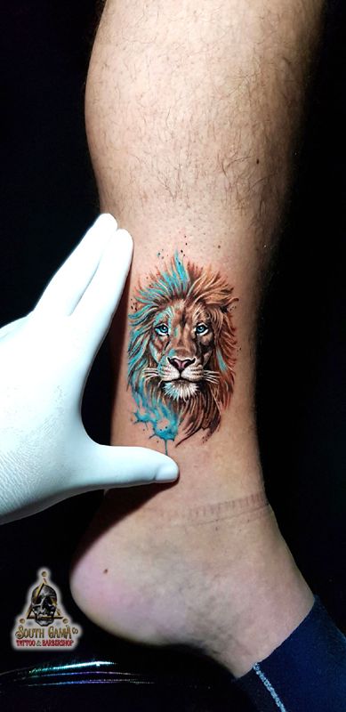 a man with a lion tattoo on his foot