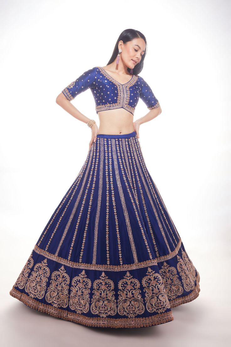 Blue silk lehenga with intricate motifs at the base and delicate lines of zardozi paired with matching blouse and net dupatta with thick main border and thinner borders on 3 sidesFrom Chamee and Palak 's The Wedding Edit collectionDELIVERY TIMEPlease allow 8-12 weeks for your outfit to arrive.FABRIC DETAILSSilk And NetProfessional cleaning only. Blue Raw Silk Sets With Cutdana, Blue Raw Silk Sets With Cutdana Details, Blue Chanderi Sets For Reception, Elegant Blue Chanderi Choli, Blue Silk Anarkali Set For Reception, Traditional Blue Gown With Zari Work, Blue Raw Silk Sharara With Cutdana, Blue Anarkali Gown In Raw Silk, Blue Chanderi Gown With Zari Work