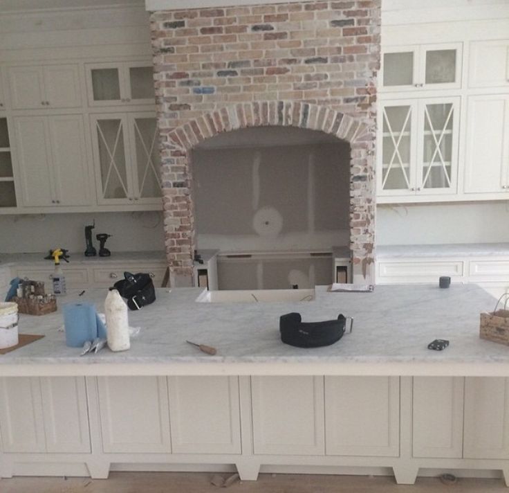 a kitchen with white cabinets and a brick oven