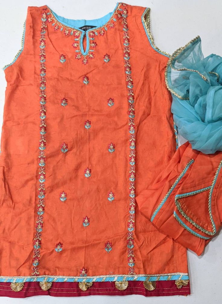 3-Piece Straight Shirt with Trouser & Dupatta This burnt orange three-piece features an embroidered kurta, separate sleeves, organza dupatta, and an intricately crafted silk tulip shalwar. Kameez (Shirt) : Orange Color jacquard shirt. Shalwar (Trouser) : Orange Color Raw Silk Tulip pants Dupatta (Scarf) : Blue Organza Dupatta. Country of Origin : Pakistan Care Instruction : Should be washed in gentle cycle and hung to dry. Color may bleed so please be mindful of other items with it. Disclaim Traditional Tissue Silk Straight Kurta Set, Designer Orange Salwar Kameez, Chikankari Embroidered Tissue Silk Sets For Navratri, Chikankari Embroidery Tissue Silk Sets For Navratri, Orange Resham Embroidery Dupatta, Semi-stitched Chanderi Churidar For Summer, Orange Resham Embroidery Churidar, Embroidered Tissue Silk Set With Straight Kurta, Organza Straight Kurta With Dori Work