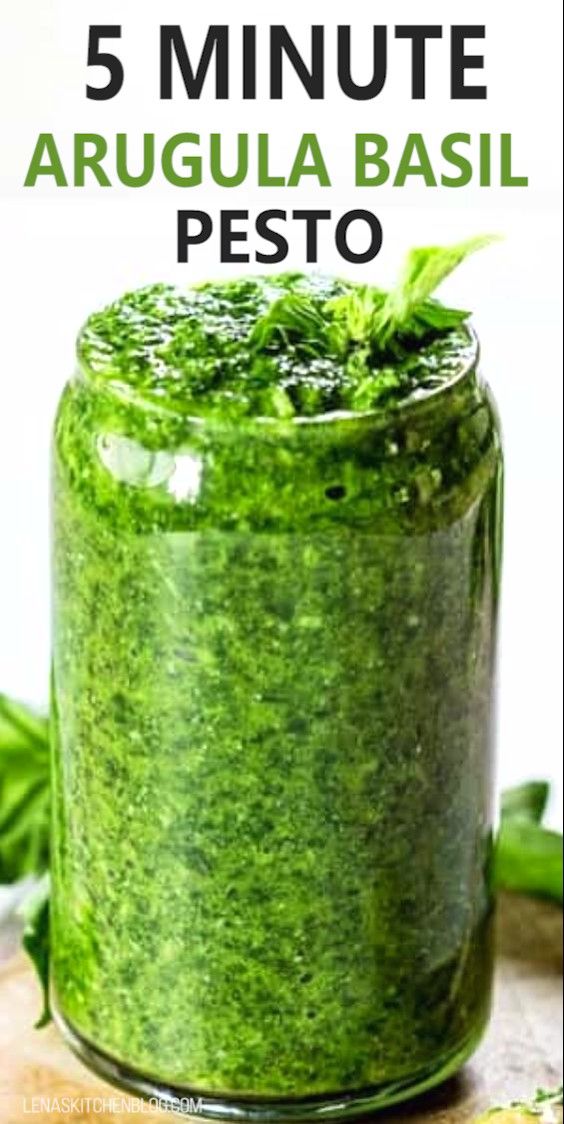 a jar filled with pesto sitting on top of a wooden table