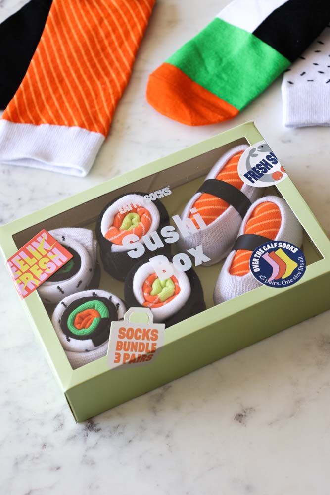 sushi boxes are sitting on a table with socks and socks in the back ground