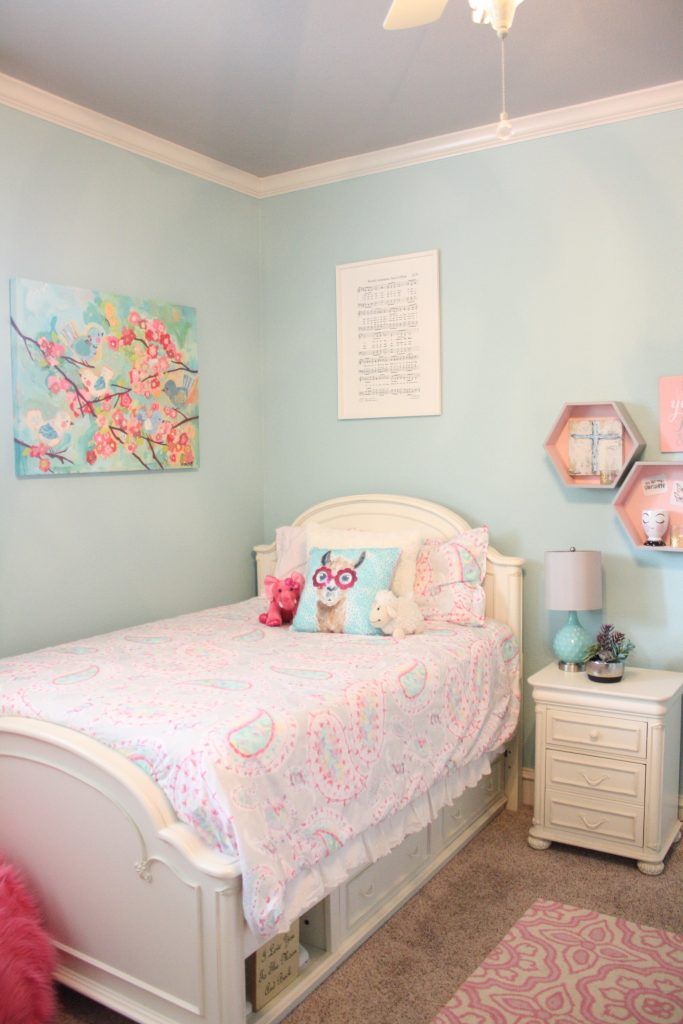 a bedroom with a bed, dresser and pink rugs on the carpeted floor