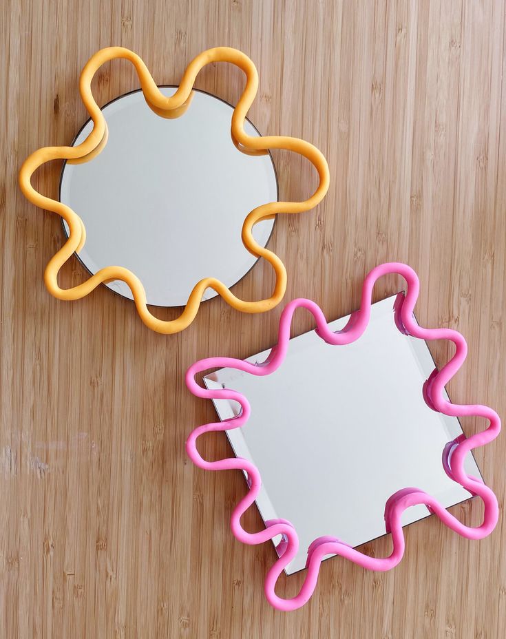 there are two cookie cutters sitting on the table next to each other, one is shaped like a flower