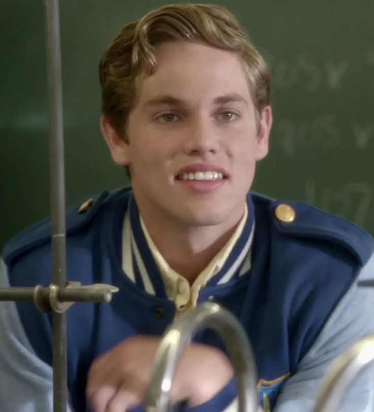 a young man in uniform is smiling at the camera