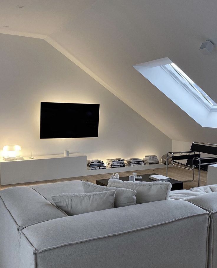 a living room filled with furniture and a flat screen tv mounted to the side of a wall