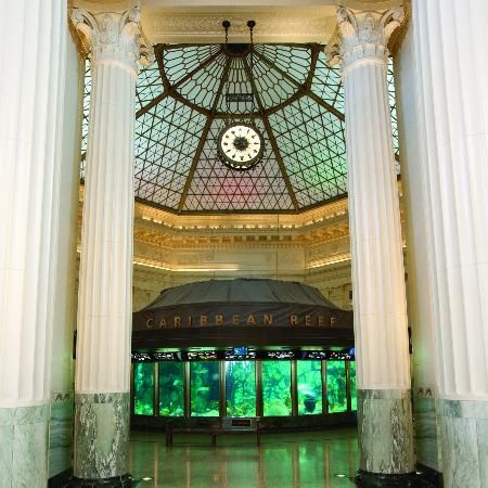 the inside of a building with columns and a clock