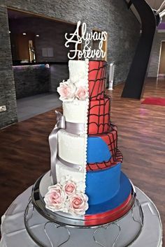 there is a multi layer cake with flowers on the top and spiderman decorations on the bottom