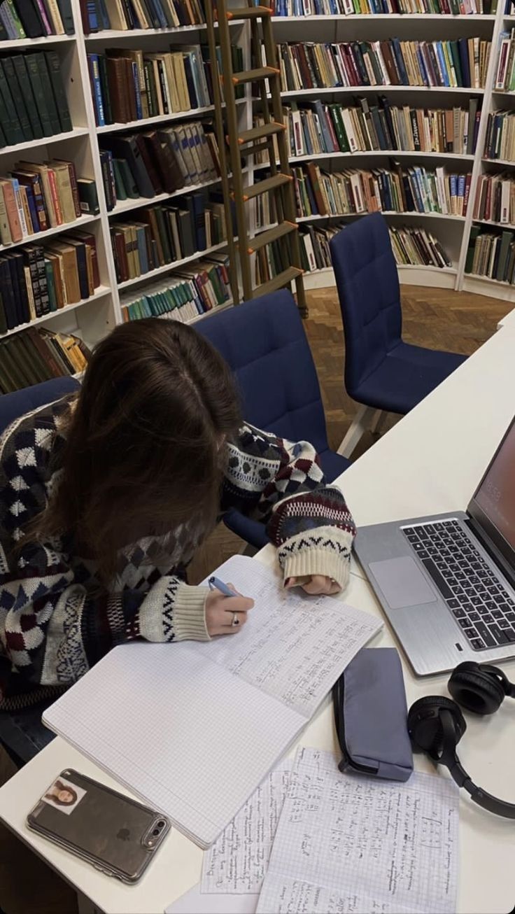 a woman sitting at a desk with a laptop computer