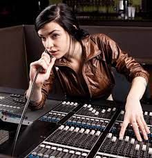 a woman sitting at a sound mixing desk