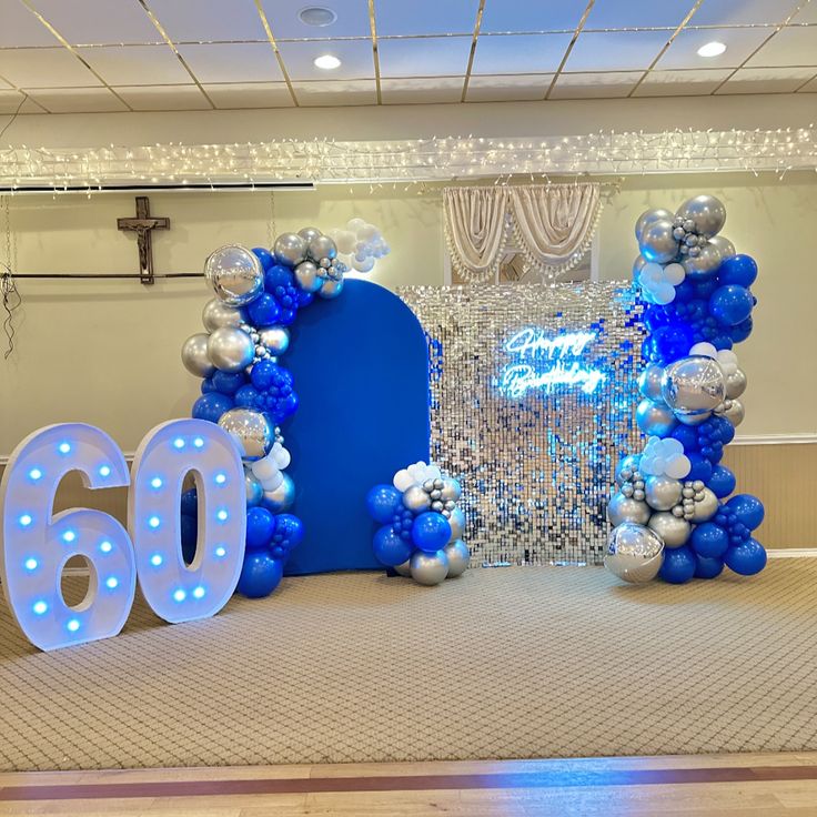 an entrance to a 60th birthday party decorated with balloons and streamers on the floor