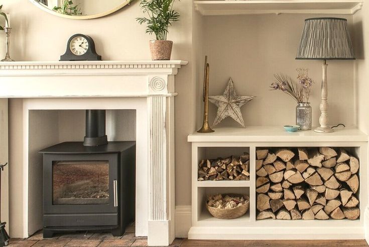 a living room with a fireplace, mirror and firewood stacked on top of each other