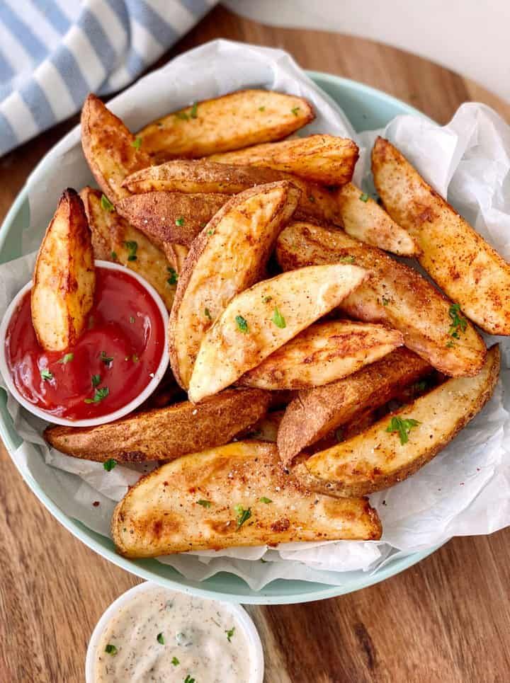 french fries on a plate with ketchup and mayonnaise