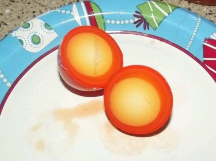 two orange eggs sitting on top of a white plate