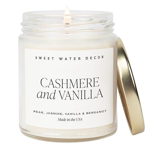 a candle that is inside of a glass jar with a gold lid and the words cashmere and vanilla on it