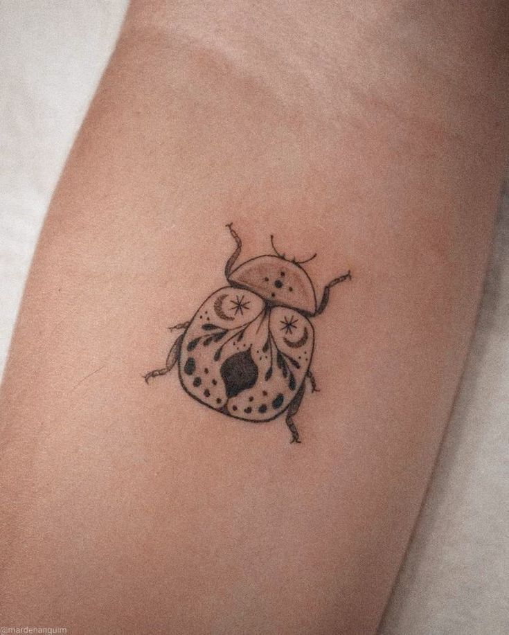 a ladybug tattoo on the right arm