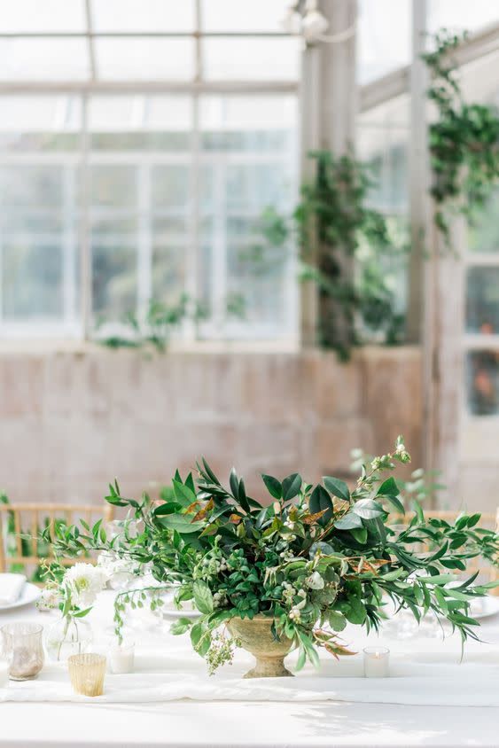 the table is set with white and green flowers