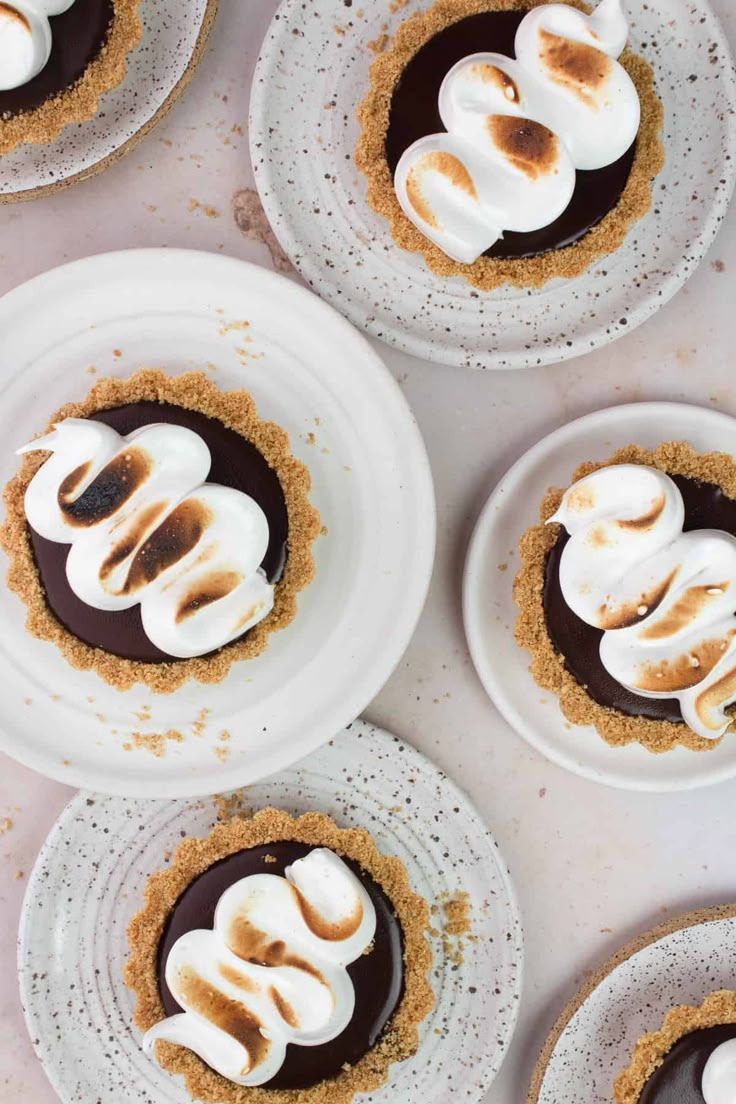 several desserts are arranged on white plates