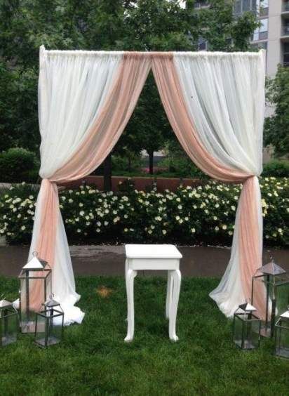 an outdoor ceremony setup with white and pink drapes