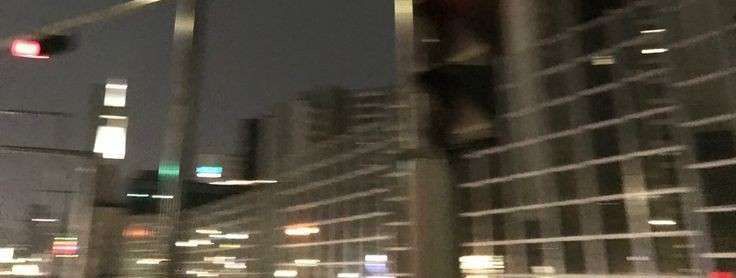 a traffic light hanging over a street next to tall buildings in a city at night