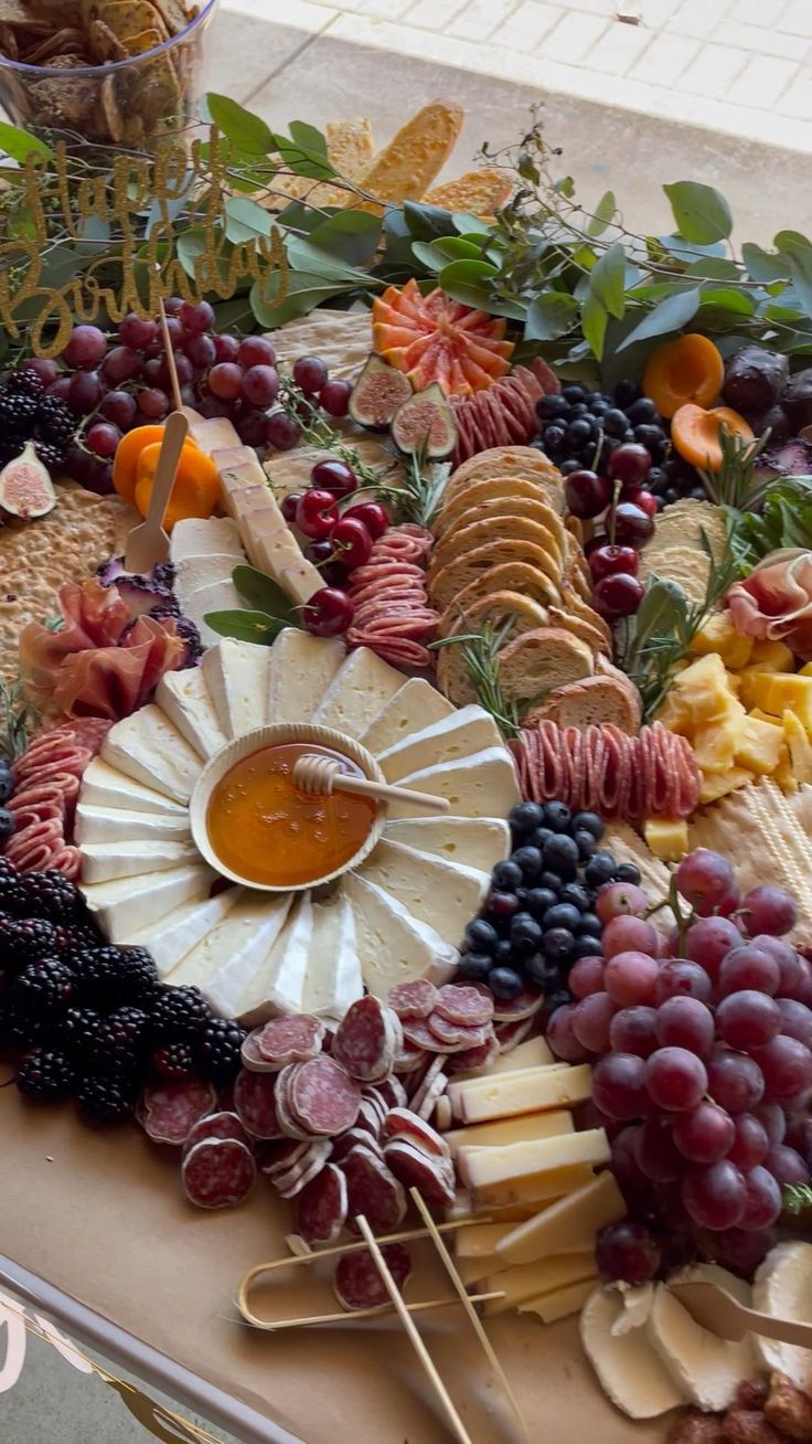 a table topped with lots of different types of cheeses and fruit on top of each other