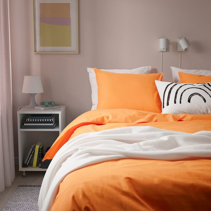 an orange and white bed in a bedroom